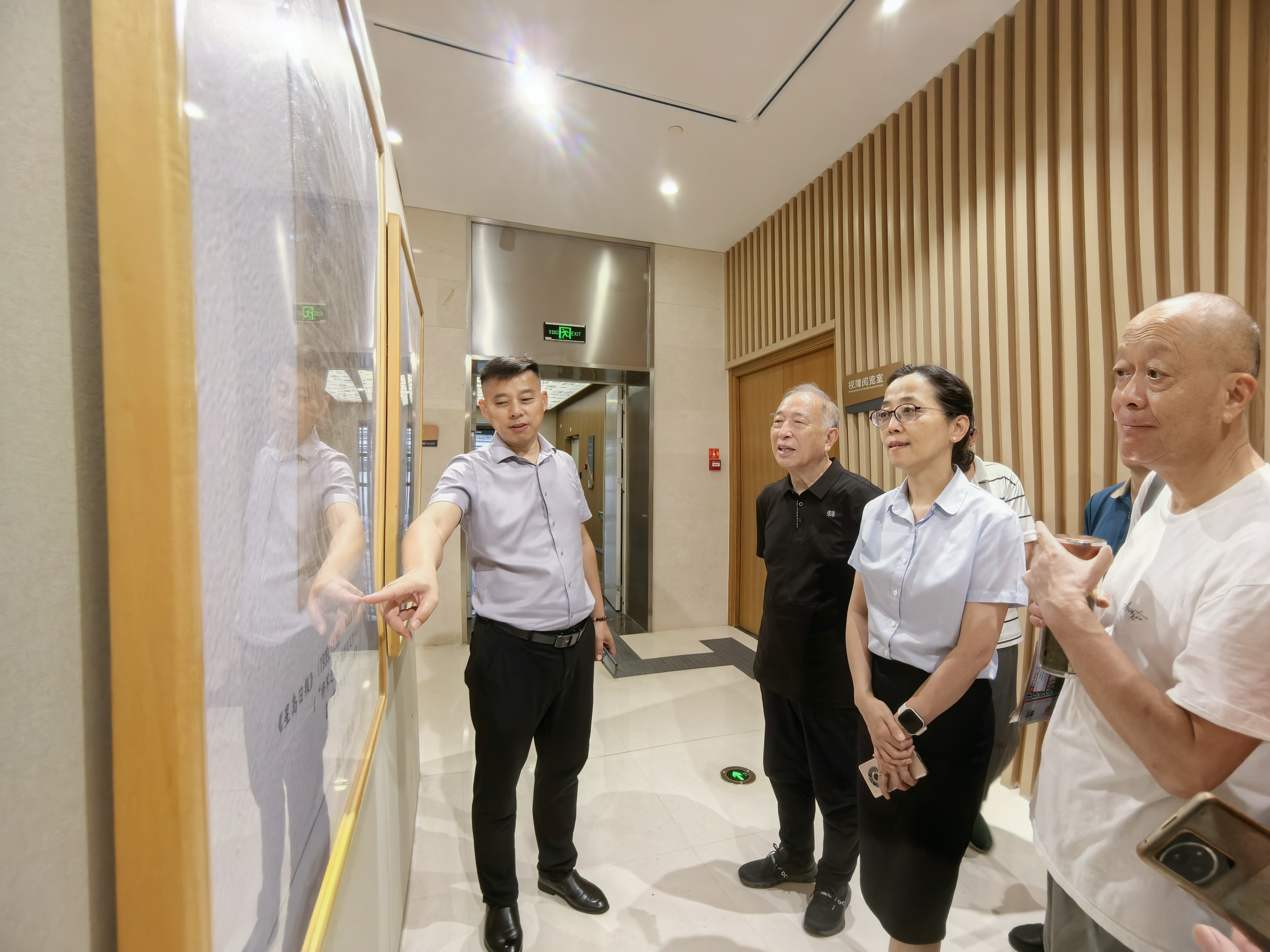 钱竑馆长、王荣泰老会长等参观展览，右一即插队参观的老读者.jpg